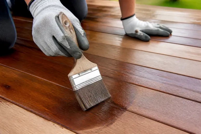 Application de saturateur sur bois pour terrasse exotique pour préserver sa couleur.