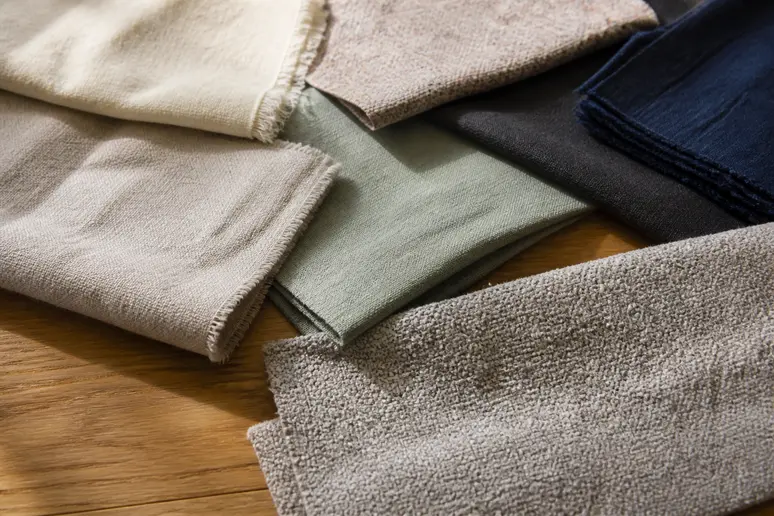 Échantillons de textiles écologiques pour un canapé : coton bio, lin, fibres recyclées.
