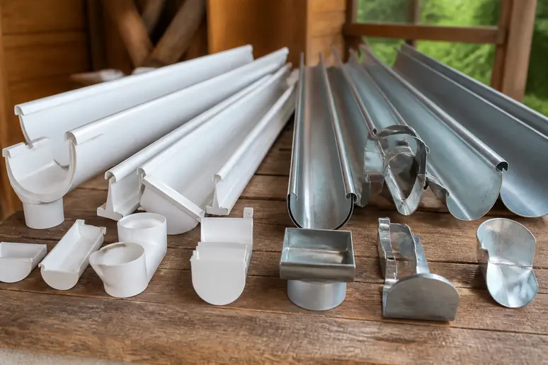 Échantillons de profilés de gouttières abris de jardin en PVC et en métal sur un plan de travail