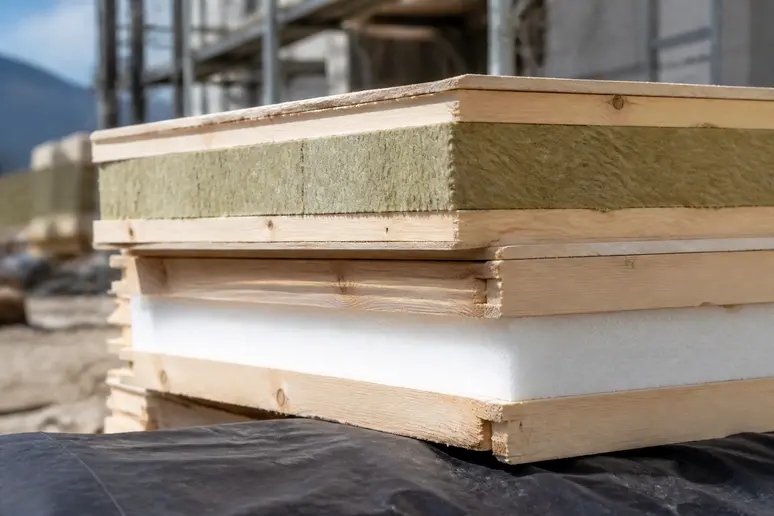 Panneaux d'ossature en bois et isolant thermique stockés sur un chantier de construction