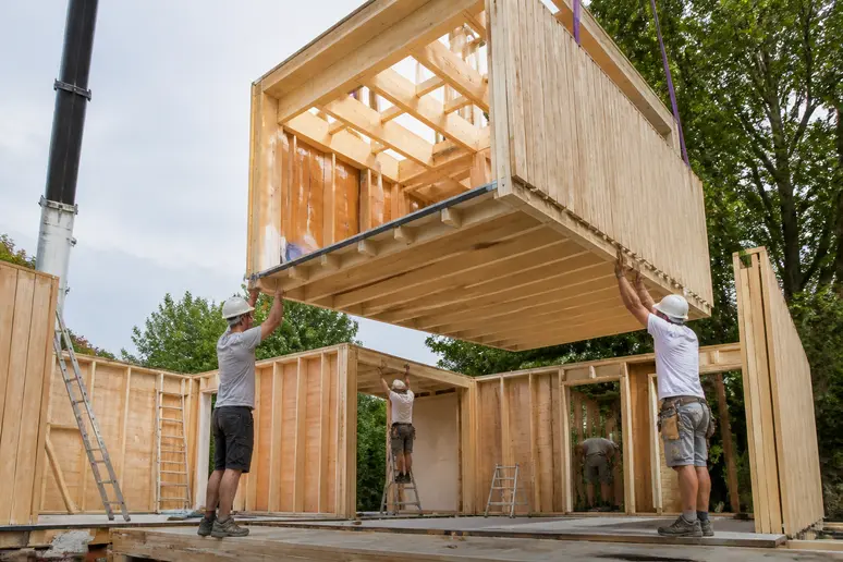 Chantier d'autoconstruction montrant l'assemblage de la structure isolée d'un bâtiment
