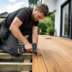Pose de lames de terrasse bois par un artisan sur un chantier extérieur ensoleillé