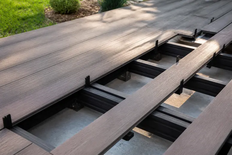 Détail de la pose de lames de terrasse composite avec espaceurs pour assurer la ventilation