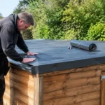 Installation d'une membrane d'étanchéité sur la toiture plate d'un abri de jardin en bois