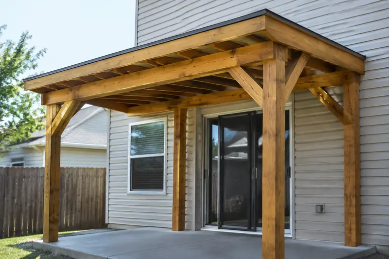 Structure de abri terrasse en bois adossé fixée solidement contre la façade de la maison