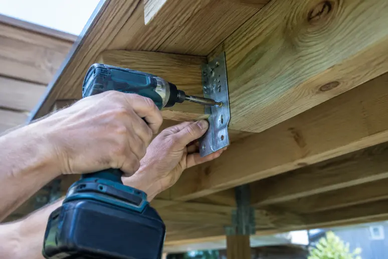 Fixation d'un garde-corps en bois sur la lambourde porteuse d'une terrasse extérieure