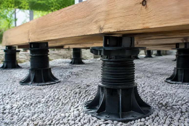 Plots réglables en plastique soutenant la structure d'une pose terrasse bois.