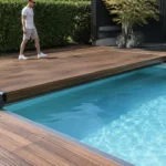 Une terrasse mobile piscine en bois robuste recouvrant partiellement un bassin extérieur lumineux